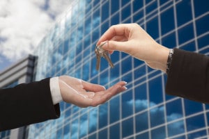 woman handing over office keys after business succession